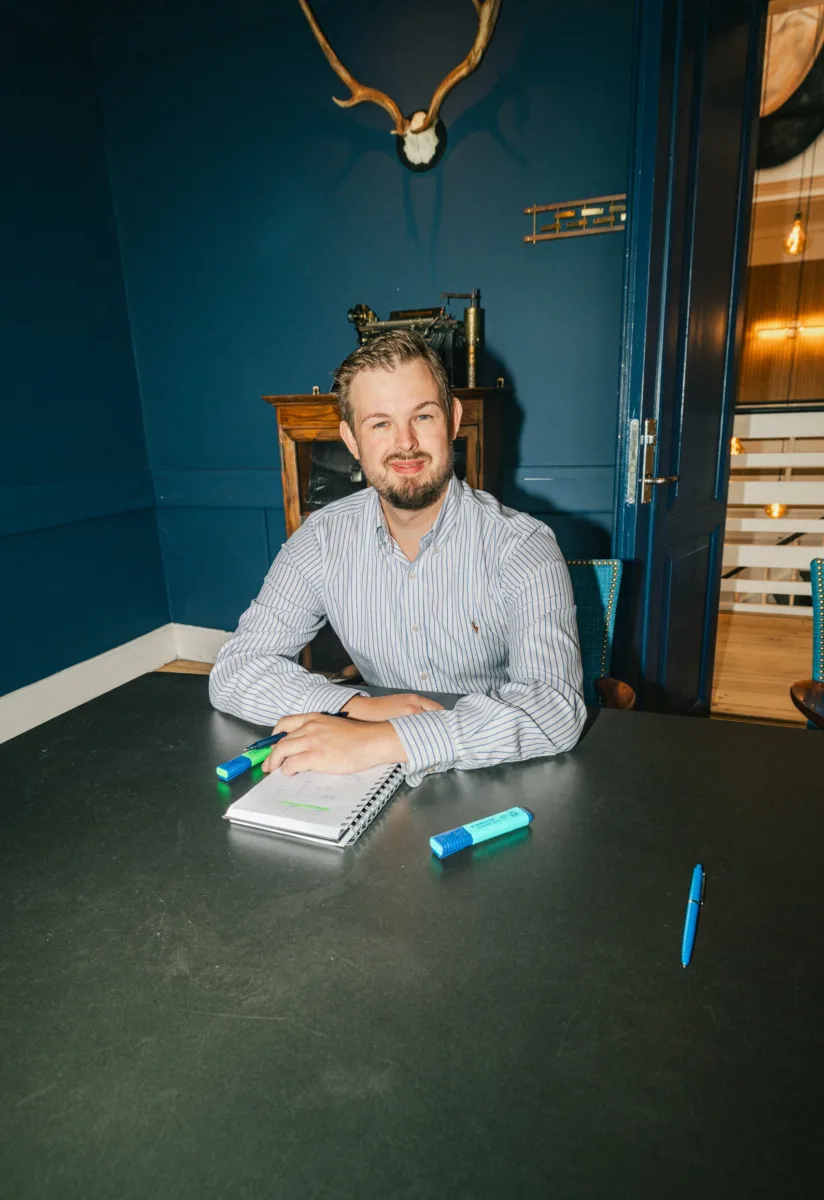 Medarbejder sidder ved et mødebord med en skitse i notesblokken foran sig