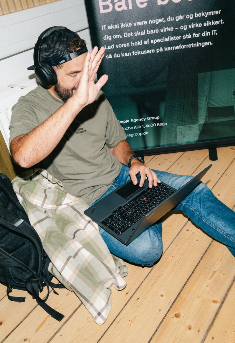 Medarbejder afviser kameraet med hånden mens den anden skriver på tastaturet