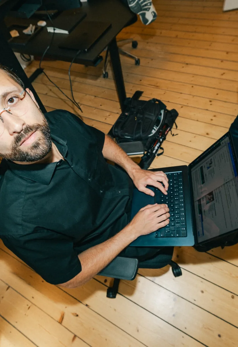Medarbejder kigger op fra en bærbar computer set fra oven i et åbent kontor