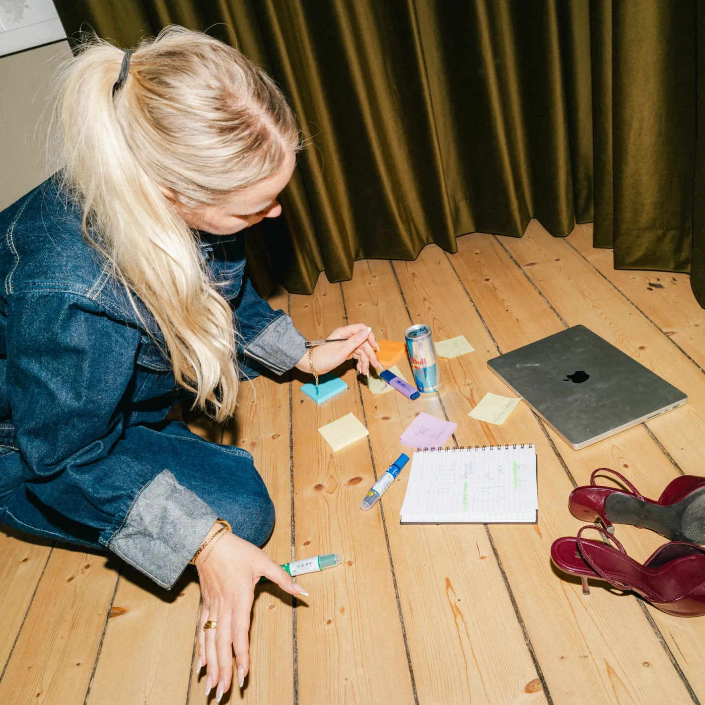 Medarbejder sidder på gulvet og arbejder med farvede post-its og markers