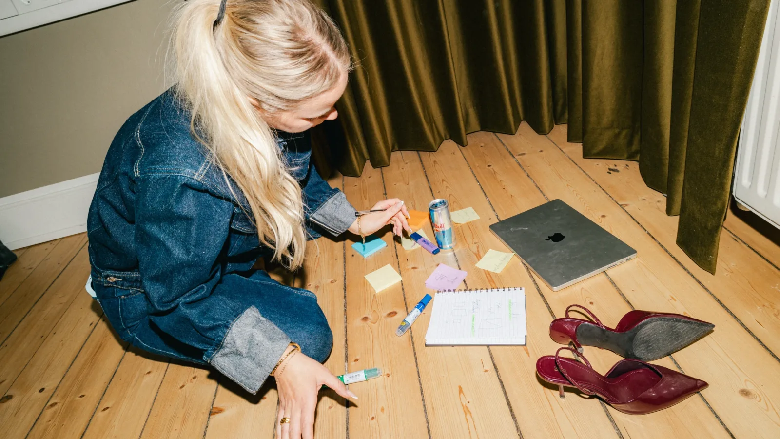 Medarbejder sidder på gulvet og arbejder med farvede post-its og markers
