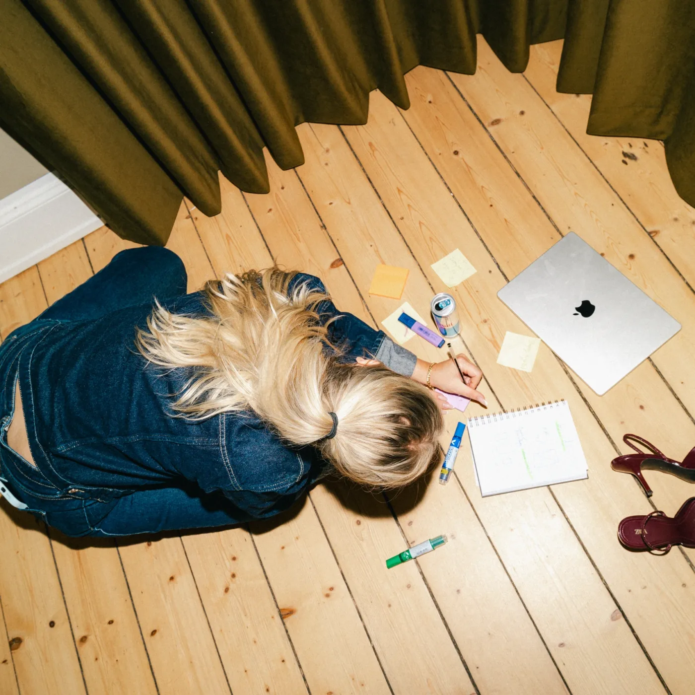 Medarbejder arbejder med skitser og post-its på gulvet set ovenfra