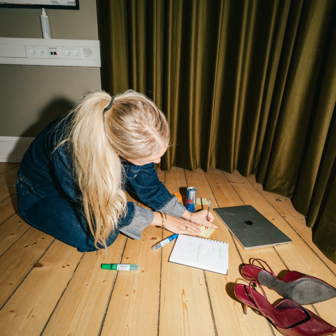 Medarbejder læner sig ind over en notesblok med skitser på gulvet