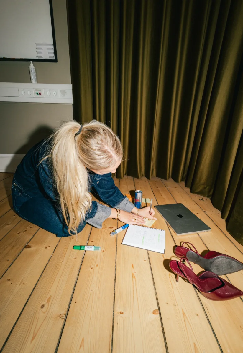 Medarbejder læner sig ind over en notesblok med skitser på gulvet