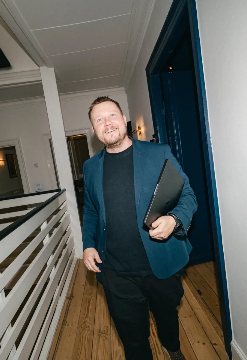 Medarbejder går gennem en gang med en bærbar computer under armen
